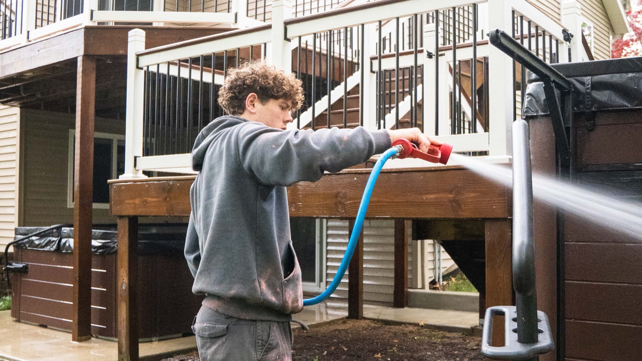 Elevation crew soft-washing a home, deck, and railing in the Grand Rapids metro